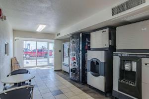 a room with a kitchen with a table and appliances at Motel 6 Cheyenne in Cheyenne