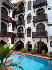 un hotel con piscina frente a un edificio en Dhow Palace Hotel en Zanzíbar