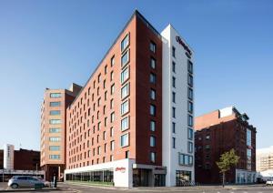 Un alto edificio rosso e bianco in una città di Hampton By Hilton Belfast City Centre a Belfast