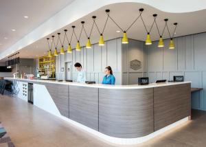 two people standing at a counter in a hospital lobby at Hampton By Hilton Belfast City Centre in Belfast