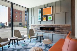 a waiting room with chairs and a fireplace at Hampton By Hilton Belfast City Centre in Belfast