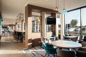 a restaurant with tables and chairs and a tv at Hampton By Hilton Belfast City Centre in Belfast