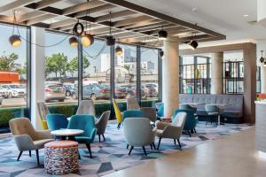 a lobby with chairs and tables and windows at Hampton By Hilton Belfast City Centre in Belfast