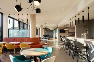 um restaurante com mesas e cadeiras e um bar em Hampton By Hilton Belfast City Centre em Belfast