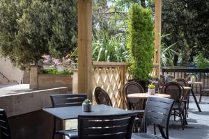 Un patio al aire libre con mesas, sillas y plantas. en DoubleTree by Hilton Bath, en Bath