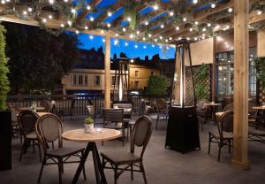a patio with tables and chairs and lights at DoubleTree by Hilton Bath in Bath