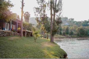 a house next to a body of water with trees at Maisondulac7 in Rubavu