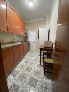 una cucina con lavandino, tavolo e frigorifero di Casa “El Zumaque” en Zahara de la Sierra a Zahara de la Sierra