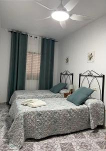una camera con 2 letti e un ventilatore a soffitto di Casa “El Zumaque” en Zahara de la Sierra a Zahara de la Sierra