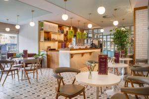 un ristorante con tavoli, sedie e bancone di DoubleTree by Hilton Bath a Bath
