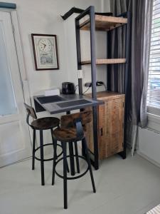 a kitchen with a table and two stools in a room at Guesthouse KST in Zandvoort