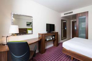 a hotel room with a bed and a desk and a television at Hampton by Hilton Birmingham Jewellery Quarter in Birmingham