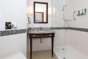 a bathroom with a sink and a shower and a mirror at Hampton by Hilton Birmingham Jewellery Quarter in Birmingham +26 photos