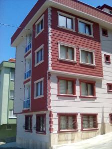 - un bâtiment rouge et blanc avec de nombreuses fenêtres dans l'établissement ÖZTÜRK Apart, à Trabzon