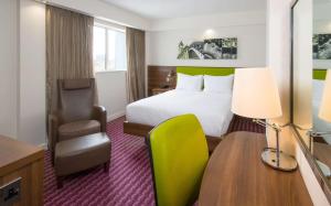 バーミンガムにあるHampton by Hilton Birmingham Jewellery Quarterのベッド、デスク、椅子が備わるホテルルームです。