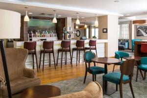 a bar in a hotel room with chairs and tables at Hampton by Hilton Birmingham Jewellery Quarter in Birmingham