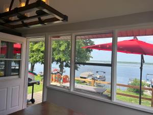 Habitación con ventana y sombrilla roja. en Snug Harbour Cottage and Marina, en Kawartha Lakes