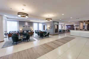 uma sala de espera num hospital com cadeiras e mesas em Hampton by Hilton Bournemouth em Bournemouth