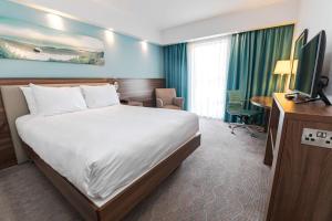 a hotel room with a bed and a television at Hampton by Hilton Bournemouth in Bournemouth
