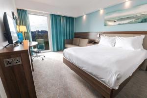 a hotel room with a bed and a television at Hampton by Hilton Bournemouth in Bournemouth