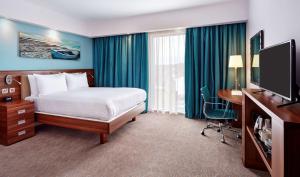 a hotel room with a bed and a flat screen tv at Hampton by Hilton Bournemouth in Bournemouth