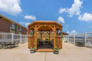 a wooden gazebo with tables and chairs on a patio at Comfort Inn Hastings in Hastings