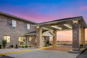 a brick building with a garage with a sunset at Quality Inn & Suites Fillmore I-15 in Fillmore