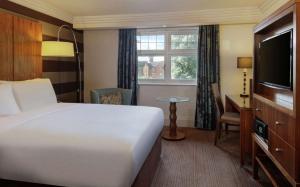 ストラトフォード・アポン・エイボンにあるDoubleTree by Hilton Stratford-upon-Avon, United Kingdomのベッドとテレビが備わるホテルルームです。