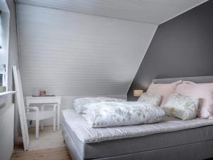 een slaapkamer met een bed en een tafel met een nachtkastje bij Holiday home Bindslev XVI in Bindslev
