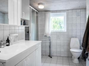宾德斯莱弗Holiday home Bindslev XVI的带马桶和水槽的白色浴室 更多27张照片