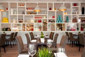 a dining room with tables and chairs and shelves at DoubleTree by Hilton Coventry in Coventry