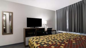 a hotel room with a bed and a flat screen tv at Econo Lodge Portage in Portage