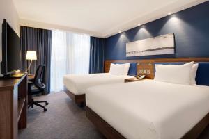 una camera d'albergo con due letti e una televisione di Hampton by Hilton Dundee a Dundee