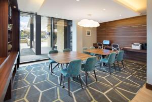 une salle de conférence avec une table et des chaises en bois dans l'établissement Hampton by Hilton Dundee, à Dundee