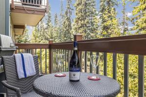 a bottle of wine sitting on a table on a balcony at Spacious King Bed with Pool & Hot Tubs in Canmore