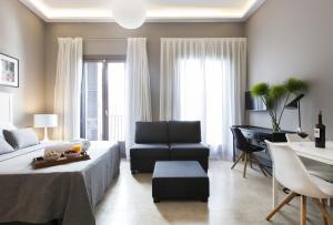 ein Wohnzimmer mit einem Bett, einem Sofa und einem Klavier in der Unterkunft Kare No Apartments by Sitges Group in Sitges