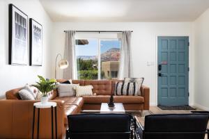 塞多納的住宿－The Saddlerock House - Great Location, Views and Hot Tub!，客厅设有棕色沙发和蓝色门