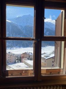 a window with a view of a snowy mountain at Villa Bochert in Zuoz