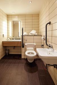 a bathroom with a toilet and a sink and a mirror at Hilton Garden Inn Doncaster Racecourse in Doncaster