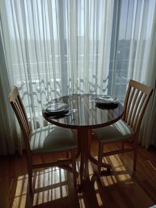 mesa de comedor con 2 sillas y ventana en MZA Departamentos en Mendoza