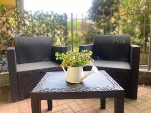 a vase of flowers on a table with two chairs at Casa Sofia Lissone in Lissone