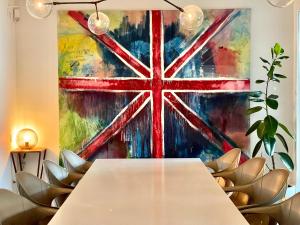 stolik w pokoju z obrazem brytyjskiej flagi w obiekcie Portopiccolo Designer Penthouse w mieście Sistiana