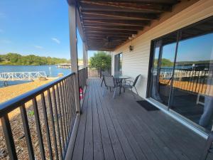 een terras met een tafel en stoelen op een huis bij Lakefront condo with a VIEW Osage Beach in Osage Beach