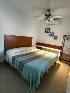 a bedroom with a bed and a ceiling fan at Departamento 5 Los Corales (tipo estudio) in Mezcales