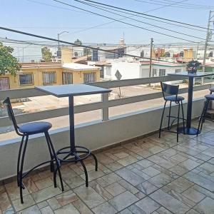 a table and chairs on a balcony with a view of a street at Departamento 5 Los Corales (tipo estudio) in Mezcales