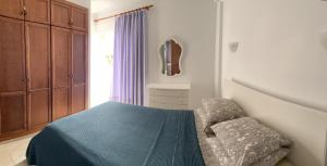 - une chambre avec un lit doté d'une couverture bleue et d'une fenêtre dans l'établissement Concanasa 43 Los Gigantes, à Acantilado de los Gigantes