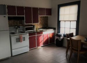 a kitchen with red cabinets and a white refrigerator at Expansive Ground Floor Pensione. in Clarkdale