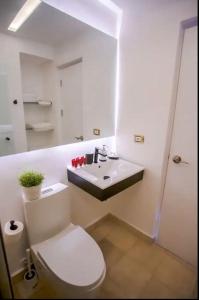 uma casa de banho com um WC branco e um lavatório. em Hard Rock at Cana Rock 2 by Unwind Properties em Punta Cana