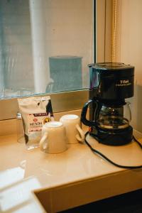 a coffee maker and two cups on a counter at Hotel Mesón de la Chinantla in San Juan Bautista Tuxtepec