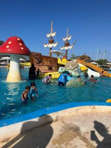 un grupo de niños jugando en el agua en un parque acuático en Marina saidia luxury Duplex pool & garden view, en Saidia 